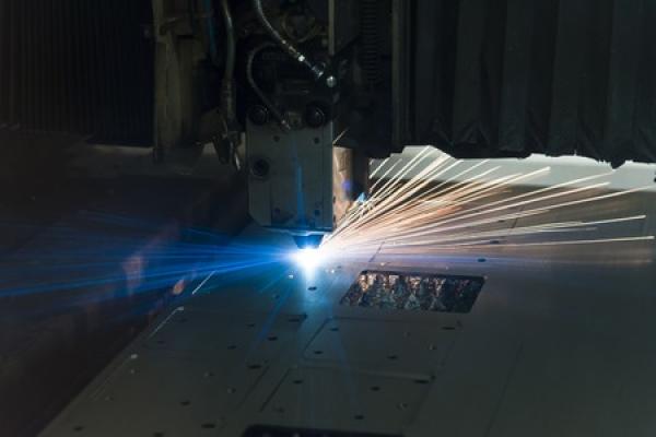 A laser cuts a piece of sheet metal