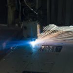 A laser cuts a pattern into sheet metal
