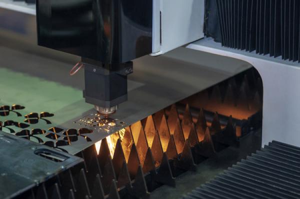 A laser cuts a pattern into sheet metal