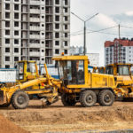 A road grader pushing dirt at a construction site