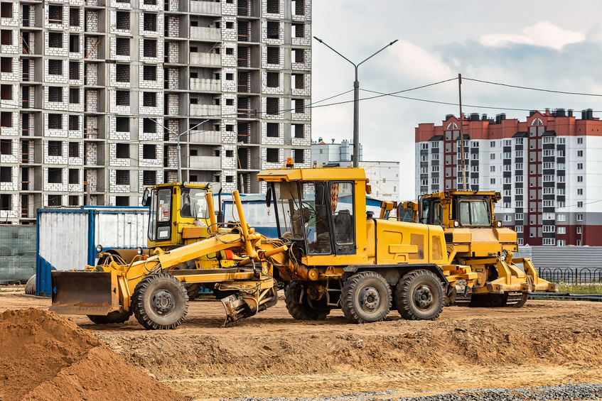 A road grader pushing dirt at a construction site