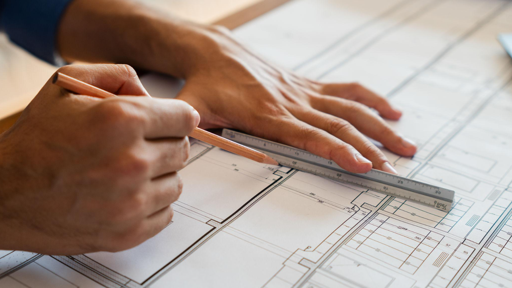 Hands reviewing architectural plans for fire training facility design
